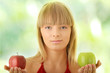Young blond woman with red and green apples