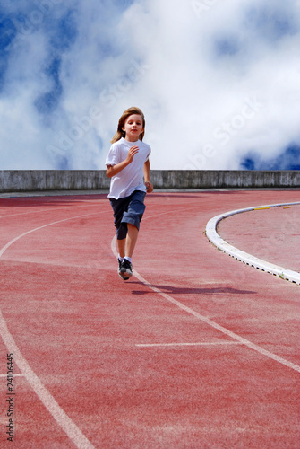 Photo: Enfant courant sur une piste d'athlétisme Enfant courant sur une piste d'athlétisme