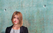 Thoughtful Attractive blonde girl by concrete wall