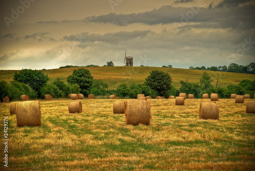 Photo: Field with hay bales and windmill in background Field with hay bales and windmill in background