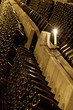 rows of wine bottles on racks in a cellar