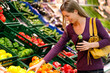 Frau im Supermarkt kauft Gemüse