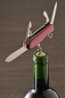 openning a bottle of wine with a corkscrew on a pocket knife