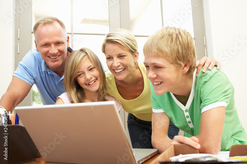 Photo: Family Using Laptop At Home Family Using Laptop At Home