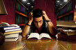 young adult student reads book at library