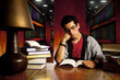 young adult student reads book at library