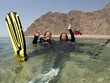 female scuba diver swimms backwards on surface