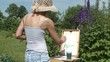 Young woman painting flowers in the garden