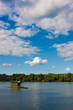 House on water with forest and blue cloudy skies