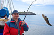 The fisherman on the boat in Norwegian fjord The fisherman on the boat in Norwegian fjord