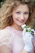 beautiful young woman in white gloves with flowers