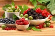 Berries in plates, on a table, among green leaves Berries in plates, on a table, among green leaves