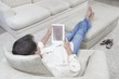 Man sits with feet up reading a digital book