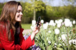 A young woman photographing flowers with her phone