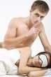 Man in bed holding a finger to his lips