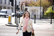 A young woman crossing the street, smiling