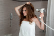 dressed in towel beautiful woman using fen at modern bathroom