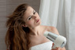 dressed in towel beautiful woman using fen at modern bathroom