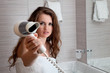 dressed in towel beautiful woman giving fen at modern bathroom
