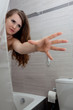 woman behind curtain streching for something at modern bathroom