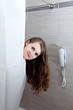 gorgeous woman behind curtain taking a shower at modern bathroom