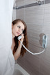 gorgeous woman behind curtain making a call at modern bathroom