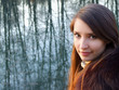 Beautiful girl in the fur coat in front of the lake