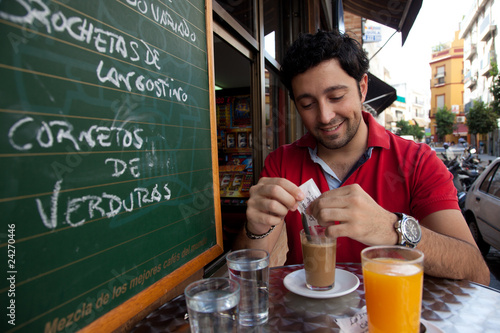 Photo: Hombre joven desayunando en Sevilla Hombre joven desayunando en Sevilla