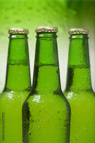 Beer bottles isolated on green background closeup Beer bottles isolated on green background closeup