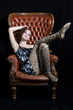 Beautiful model, photographed sitting on a big Chair