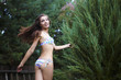 Happy attractive girl in bathing suit running on garden.