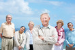 Happy old man standing with his friends in background