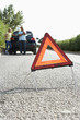 Couple Broken Down On Country Road With Hazard Warning Sign Couple Broken Down On Country Road With Hazard Warning Sign