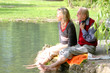 Großvater und Enkelin beim Entspannen im Grünen am Teich Großvater und Enkelin beim Entspannen im Grünen am Teich
