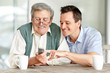 Young son teaching his father to operate a mobile