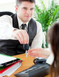 Charming salesman giving car's key to his customer