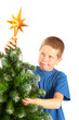 Young boy grimacing while decorating Christmas tree