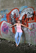 Pretty Young Adult Model Posing Agiast Graffit Wall