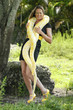 Young woman plays with an albino burmese python