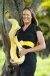 Young woman plays with an albino burmese python