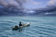 Young man in sea kayak under dramatic skies