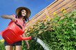 Cheerful girl watering flowers
