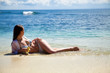 Photo: Young dark haired model lying in water on the beach Young dark haired model lying in water on the beach