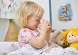 little girl in bed drinking water