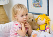 little girl in bed touching throat