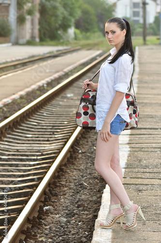 Photo: Beautiful young girl being ready to travel with train Beautiful young girl being ready to travel with train