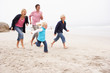 Young Family Running Along Winter Beach