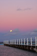 Full moon rising over the ocean at sunset
