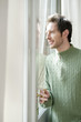 man looking out through a door glass