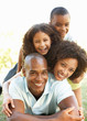 Portrait of Happy Family Piled Up In Park 